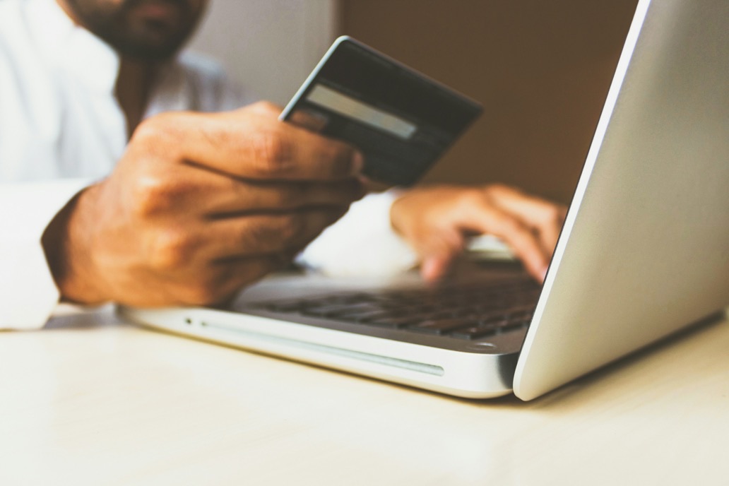 Small business owner making a card payment at a laptop