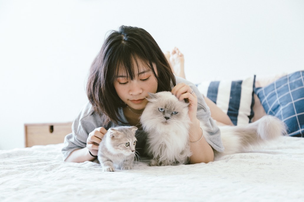 Woman cuddling her cat while using the Paw app